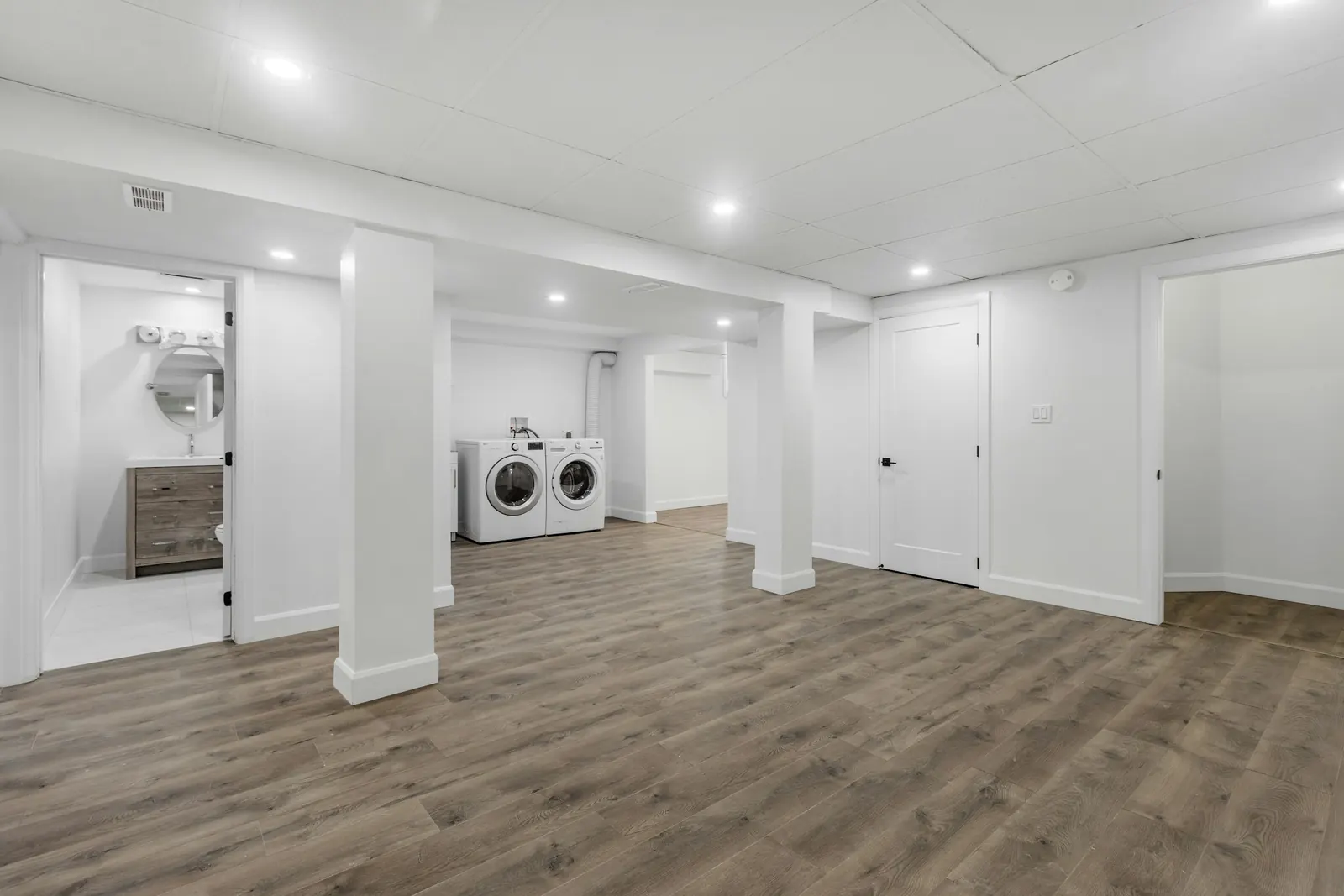 A finished basement, open plan, with the laundry at one end
