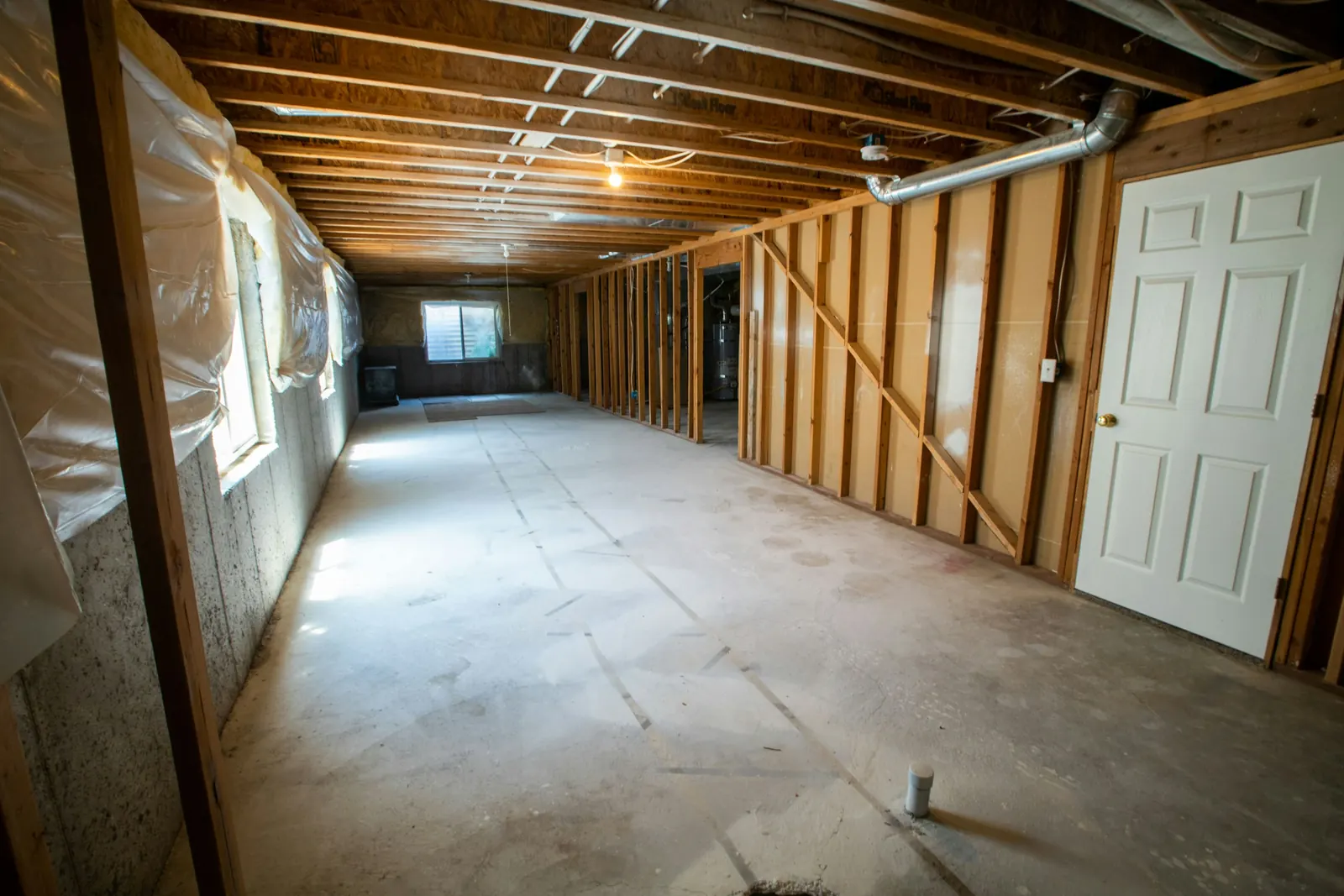 A basement with new wood-framed walls on a bare concrete floor