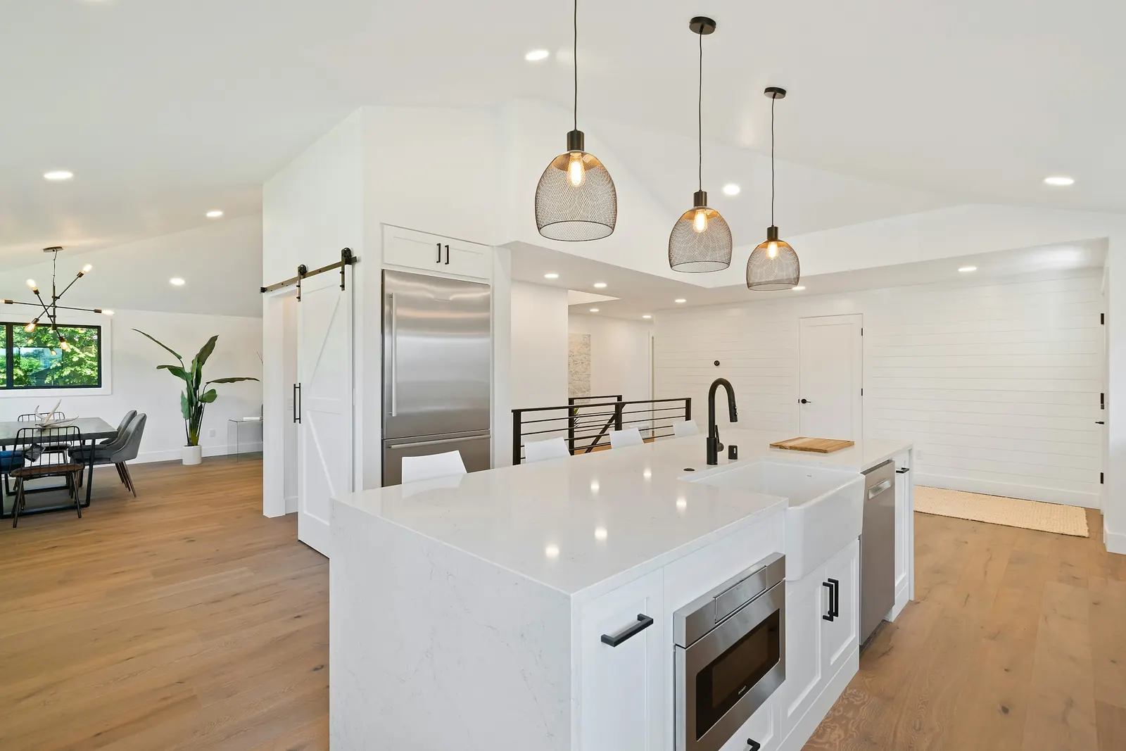 An open-plan kitchen with a white island on a wood floor